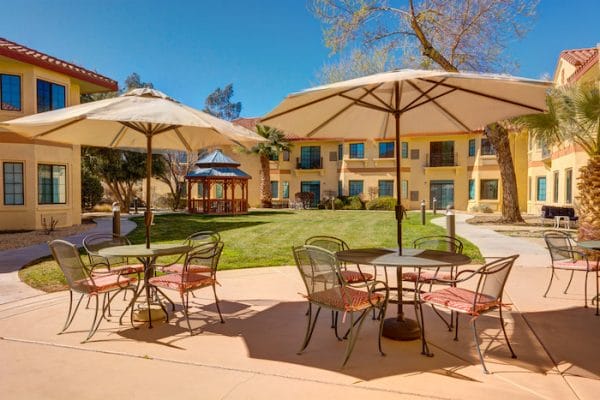 Outdoor dining tables under umbrella on The Havens at Antelope Valley patio
