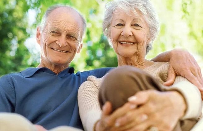 Senior couple seated and smiling