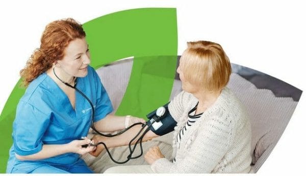 CenterWell Home Health caregiver checking female patient's blood pressure