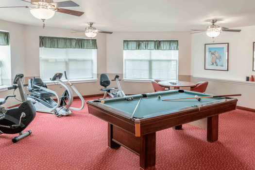 Pool table and fitness equipment in the Diamond Ridge activity room