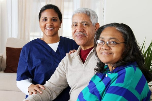 Caregivers That Deliver worker posing with senior couple