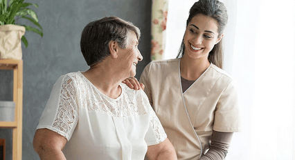 Senior woman smiling with female AAA T.L.C. Health Care caregiver