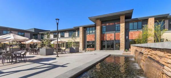 Merrill Gardens at Anthem courtyard with waterfall and many tables for residents