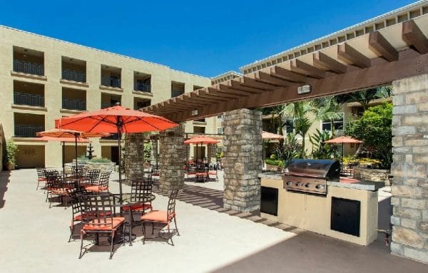 Outdoor Patio with Seating Area and Grill at Outdoor Lawn Chess Board and Seating Area at FountainGlen at Pasadena