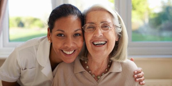 Americare Plus caregiver laughing and smiling with senior woman