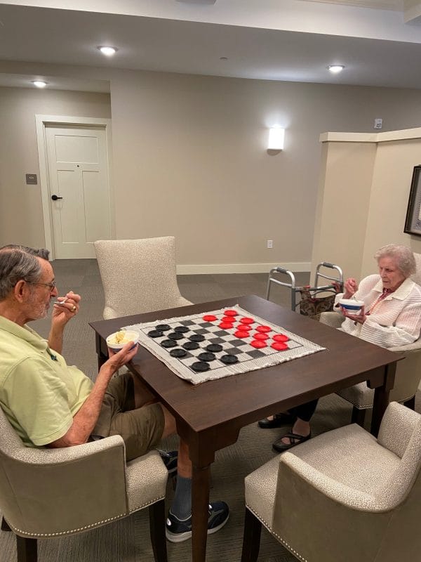 Senior couple playing oversized checkers at Westminster Memory Care Lexington