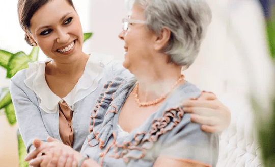 The Wellington at Southport caregiver embracing senior woman