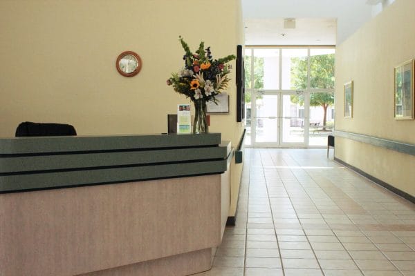 Resception desk and hallway leading to glass door entrance at Terrace Health and Rehabilitation Center