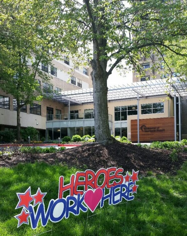 Heroes work here sign in front of the Residences at Vantage Point entrance and building