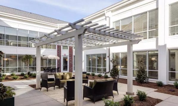 Outdoor seating under the trellis at Merrill Gardens at Madison