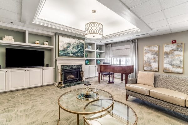 Oakleaf Village - Lexington community living room with grand piano and fireplace