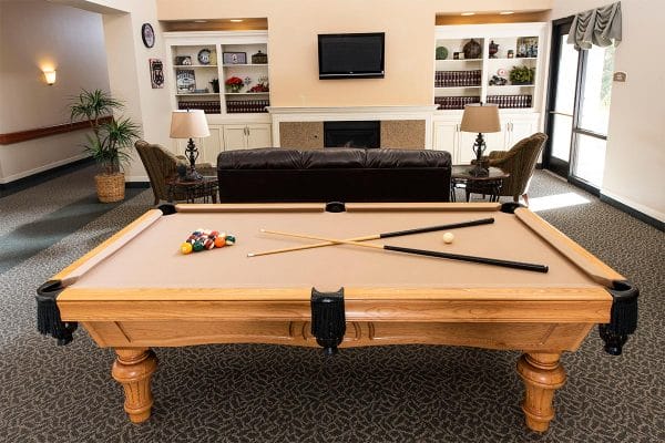 The Inn at Freedom Plaza community billiards room with a tan felt covered pool table and tv area