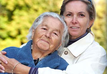 Caregiver embracing a senior woman