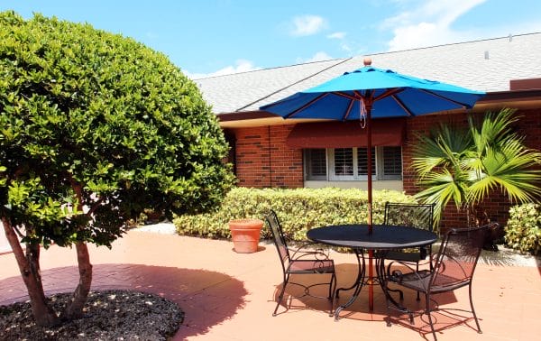 Wilton Manors Health and Rehabilitation Center outdoor courtyard with umbrella tables