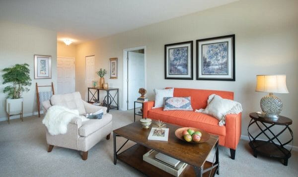 Orange sofa in a Linden Ponds model apartment home