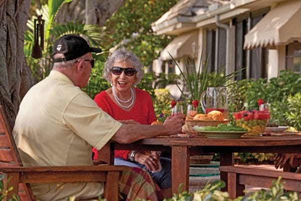 Senior man and woman dining outside at Abbey Delray North