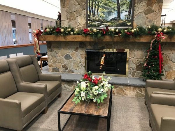 Fireside seating and Christmas decorations in the Linden Ponds community living room