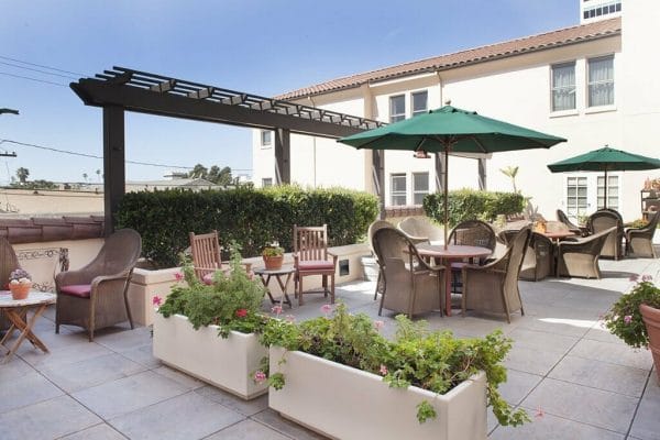 Outdoor Patio with Table and Umbrella as well as flower pots at Sunrise of Santa Monica