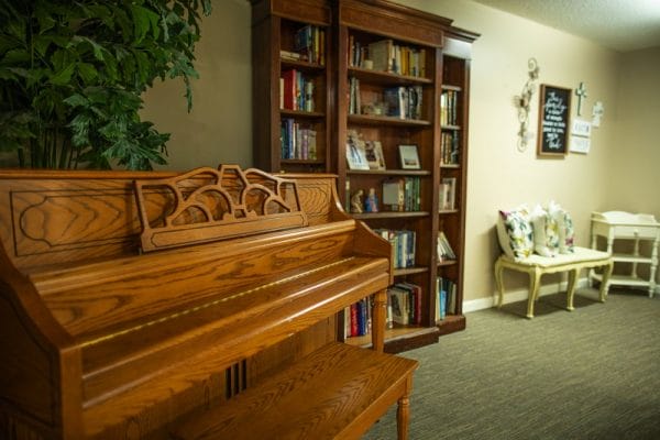 Harbison Shores community recreation room with piano and bookshelves