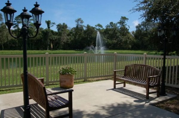 Outdoor benches overlooking pond at Grand Villa Of Ormond