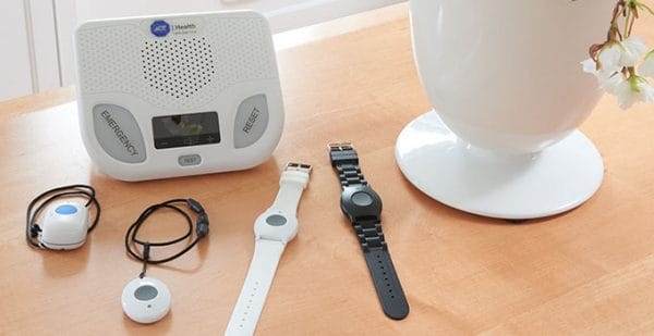ADT medical alert wristwatches next to a monitoring device