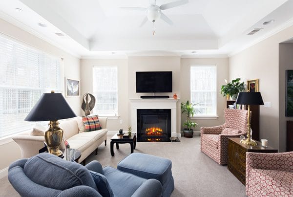 Model living room with fireplace at Abbotswood at Irving Park