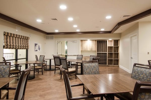 American House Coconut Point activity room with wood floors and resident seating