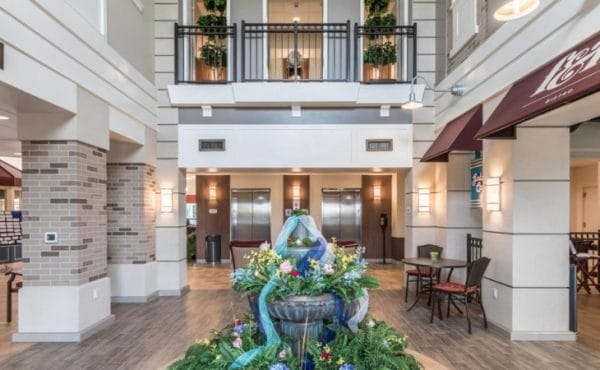Lobby and resident area with water fountain and balcony at American House Wyoming