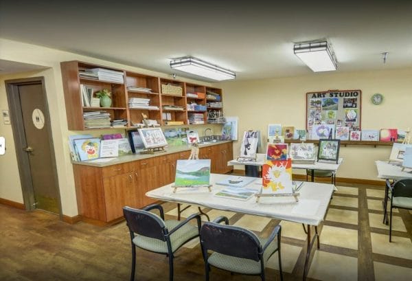 Art studio at Cypress Court with art table, supplies and art paintings