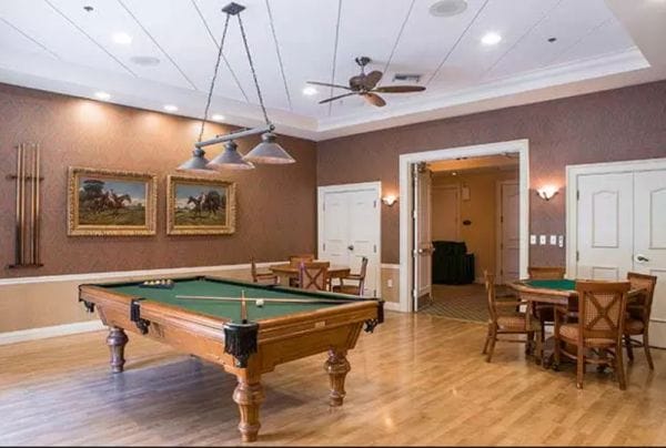 Pool table and card game play area in recreation room at Aston Gardens at Parkland Commons