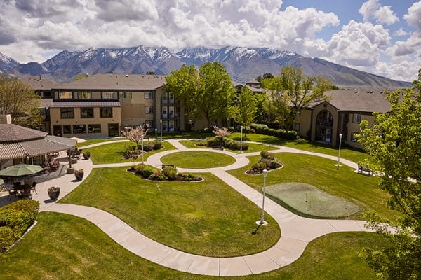 The grounds of Cedarwood at Sandy with mountains behind the building