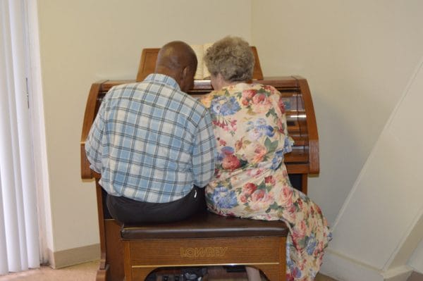 Two seniors playing piano at New Port Richey Center for Assisted Living and Memory Care