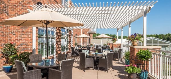 Trellis covered deck with resident seating tables at Windsor Run