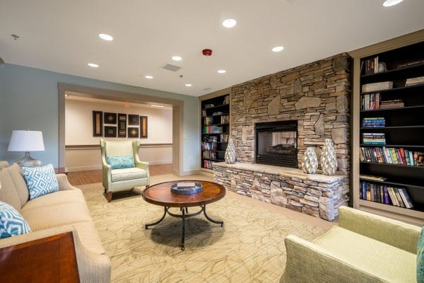 Discovery Village At Sugarloaf community living area with large stone fireplace and comfortable seating