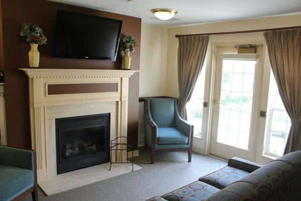 Community lounge with fireplace and tv in Charter Senior Living of Annapolis
