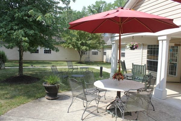 Red umbrella diningg table in the Charter Senior Living of Annapolis courtyard