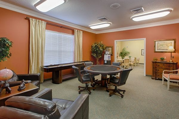 The Brennity at Melbourne card and game room with dark poker table and chairs