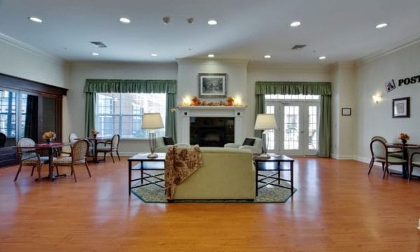 Community living room with hardwood floors and fireplace at Waltonwood Cary Parkway