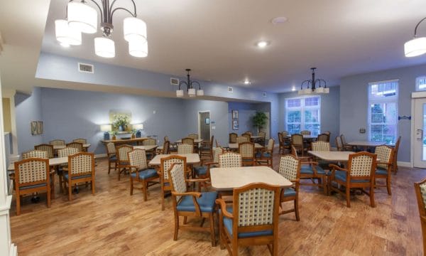 Main dining room at Keystone Place at Terra Bella with four top tables and upholstered chairs