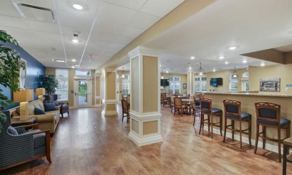 Keystone Place at Terra Bella resident lounge with high top bar and tables and chairs over hardwood floors