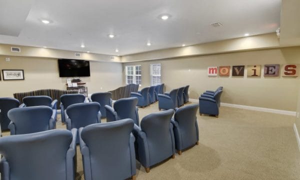 Movie theater room at Keystone Place at Terra Bella with overstuffed blue chairs and large screeen tv