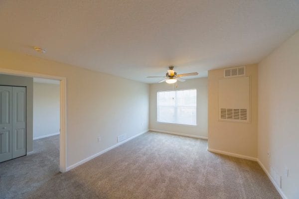 Living room with large window with blinds and ceiling fan at Mary Eaves Apartments
