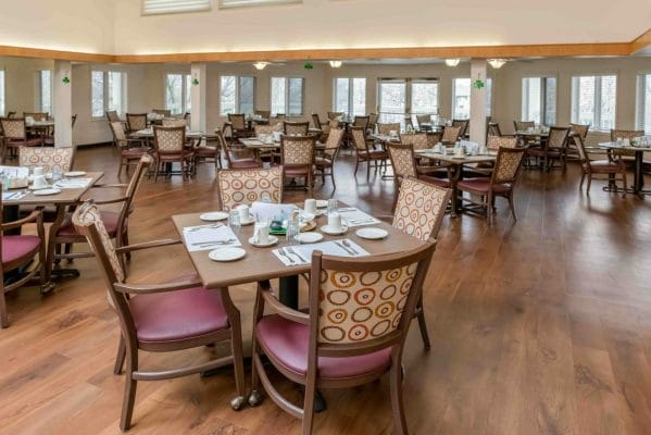 Large social dining area with multiple tables that seat four people at Hilltop Estates