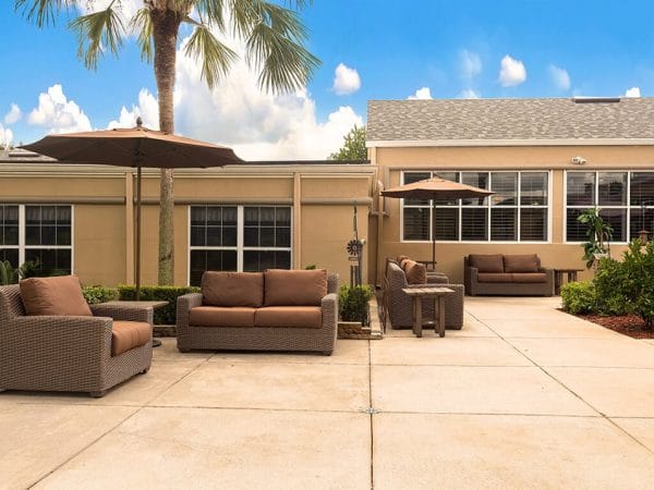 Outdoor patio at Pacifica Senior Living Ocala with couches and umbrellas
