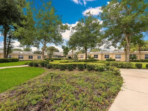 Pacifica Senior Living Ocala walking paths lined with trees and shrubs