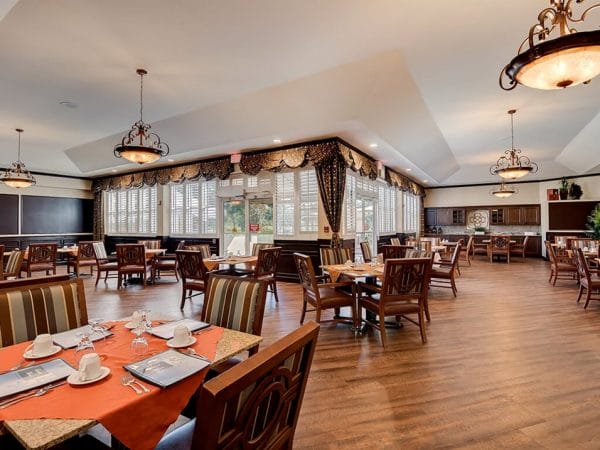 Teh dining room at Pacifica Senior Living Ocala with hardwood floors and large tables