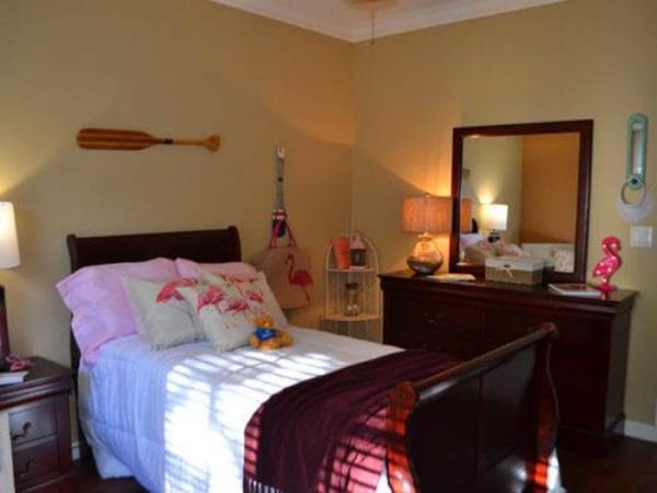 Pacifica Senior Living Fort Myers nodel resident bedroom with sleigh bed and dresser with mirror