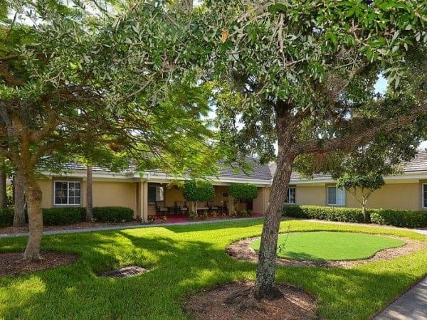 Outdoor courtyard at Pacifica Senior Living Fort Myers filled with trees and lawn
