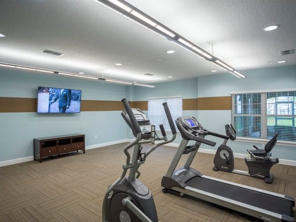 Exercise equipment and tv in the fitness center of Peyton Ridge Apartments