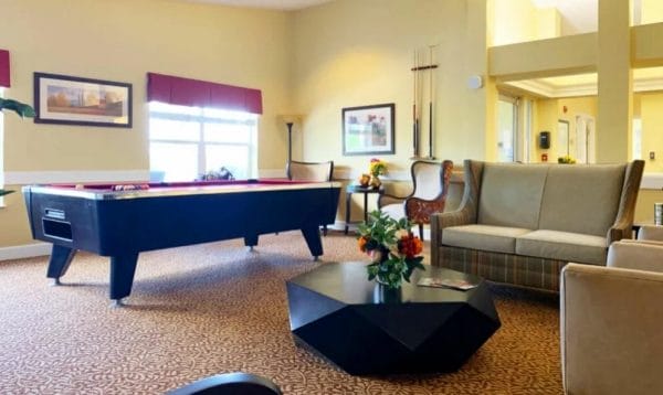 Entertainment area including pool table and loveseats at Lassen House Senior Living